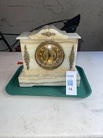 Full view of the marble antique mantle clock showing the marble case with veining and brass decorative pieces.