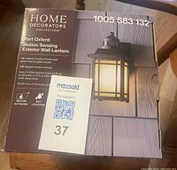 Box showing front label and product image of Home Decorators Collection Port Oxford Motion Sensing Exterior Wall Lantern.