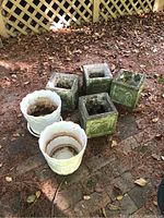 Photo showing all six planters: four square concrete planters and two white ceramic planters with one dish.