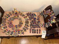 Full view of two circular woven wreaths decorated with Guatemalan dolls and a set of small dolls arranged on a bench.
