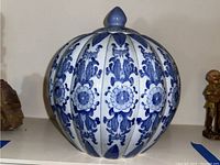 Front and side views of a blue and white ceramic jar with lid.