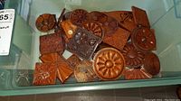 Top view of assortment of carved wood blocks in plastic bin showing various floral and geometric designs