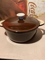 Brown glazed ceramic crock with white lid and knob handle, shown closed.