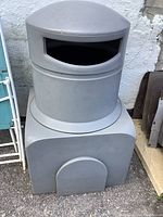 Photo showing full gray commercial garbage bin with removable lid and opening for trash disposal; outdoor placement.