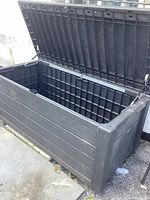 Full view of the black plastic garden storage box with the lid open.