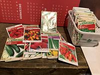 Display of multiple packets of organic produce seeds by McKenzie spread on a table showing variety of vegetables like radishes, peppers, zucchini