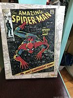 Canvas print showing the colorful front cover of The Amazing Spider-Man comic issue 100 with Spider-Man, surrounded by black and white comic strip border.