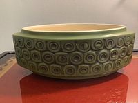 Front angled view of the oval planter showing the green circular pattern around the outside with a cream-colored interior.