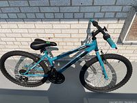 Full view of the blue Movelo 14 inch bicycle showing pedal, seat, and wheels with knobby tires.