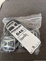 Four Honda center caps in a transparent plastic resealable bag with a label indicating 'Honda'.