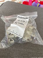 Four Hyundai centre caps in a sealed plastic bag with auction label.