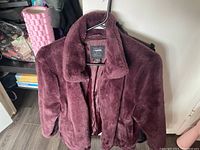 Burgundy plush womens CI Sono jacket size small shown on hanger with visible label and zipper, plush texture and collar visible