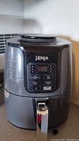 Front view of black and gray Ninja Air Fryer showing digital control panel and buttons.