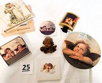 Overview of the assorted angel motif items including night light, trivet, wax angel head, coasters, photo album, and tiles