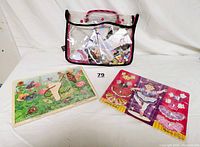 Clear carrying bag containing ballerina dress-up puzzle pieces and magnetic dolls, showing overall lot contents