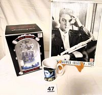 Elvis Presley anniversary clock in original box, black and white metal picture on easel, and Elvis mug arranged together