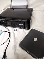 Epson XP-400 printer and Apple iPad side by side with cables on white background.