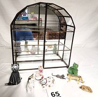 Front view of the display case with 9 cat figurines arranged outside and inside, showing case shape and reflective mirror back