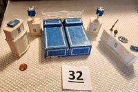 Full set of vintage Marx MPC bedroom dollhouse furniture arranged on a textured white surface with a coin for scale and item number card present. Includes bed, nightstands with lamps, bureaus, and decorative miniatures.