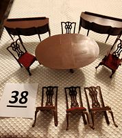 Vintage Marx Little Hostess miniature dollhouse dining room set with oval pedestal table, six chairs (some with red velvet seats, others missing legs), two hostess buffets each with drawers and doors.