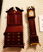 Photo of closed grandfather clock and closed secretary desk, showing front details and hardware