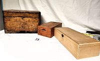 Three old wooden boxes aligned side by side showing different sizes and wood coloring.