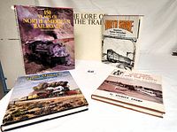 Full view of 5 hardback railroad books arranged on a white surface, showing covers and dust jackets of 4 books.