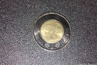 Reverse side of the 2022 Black Toonie coin featuring a polar bear design and denomination markings with 'CANADA 2 DOLLARS'.