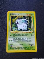 Front view of the Nidoran card from the Jungle set showing artwork, HP, attack details, and set symbol.