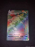 Front view of full art Stonjourner VMAX Pokémon card with rainbow holo foil effect showing the holographic shine and card details.