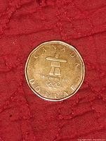 Obverse side showing Vancouver 2010 Olympic logo and Inukshuk figure with Olympic rings.