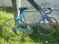 Full side view of blue vintage road speed bike showing frame geometry, wheels, drivetrain, and saddle.