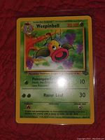 Front of the Weepinbell Pokemon card exhibiting card details such as HP, moves, and background artwork.