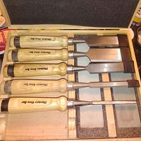 Chisels neatly arranged inside a foam-lined box showing brand "Monkey King Bar" on handles.