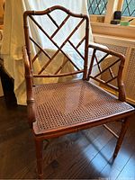 Front angle showing entire chair structure, bamboo style frame and cane seat visible