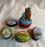 Photo showing the set of 5 ceramic travel-themed decorative boxes with painted and sculpted landmarks.