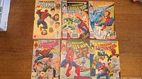 Lot of six comic books from The Amazing Spiderman series laid out on a wooden surface
