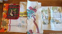 Overview of the lot linens showing folded pieces with various patterns and prints including holiday and autumn themes