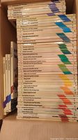 Stack of 52 children's Bible story books, titles visible, arranged horizontally.