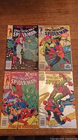 Lot of four Spectacular Spider-Man comic books laid flat showing different cover art including Spider-Man fighting villains and team-ups.