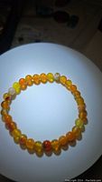 Top view of natural yellow agate bead stretchy bracelet showing color variations and round polished beads.