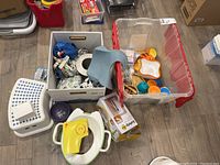 Overview of baby items including potty, seat reducer, storage bins with various baby feeding and safety accessories