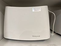Front view of white Honeywell humidifier showing brand logo and smooth panel design.