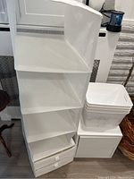White hanging fabric organizer with multiple compartments next to three marble-patterned white plastic buckets and cube drawer unit