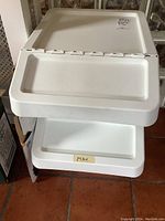 Front view of two stacked white plastic recycling bins showing surface and top trays