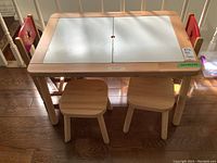 Front view of pine table with white removable panels and two stools beneath