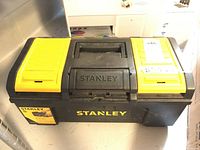 Front view of closed Stanley toolbox showing handle, latches, and brand name.
