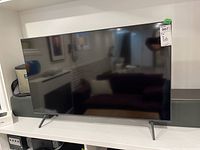 Front view of TV on stand showing screen and legs