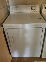 Front view of white GE electric dryer showing control panel with dials and front door.