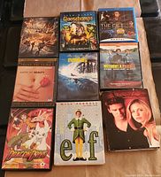 Photo of a collection of 10 DVDs including The Darkest Hour, Goosebumps, The Gift, American Beauty, The Abyss, Without a Paddle, Dragon Drive, Elf, and Buffy multi-disc set